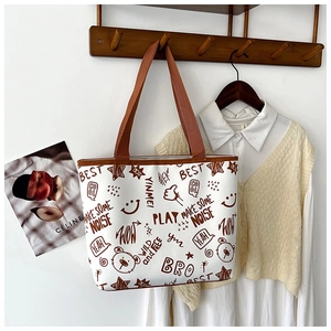 Detailed view of printed canvas tote bag with graffiti art hanging on a wooden wall hook