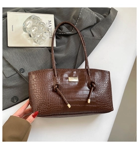 Détails du sac cabas marron foncé aspect crocodile avec plaque métallique et nœuds élégants