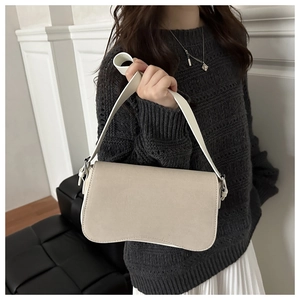 Detail of minimalist beige shoulder bag with a unique wavy curve design and matte finish