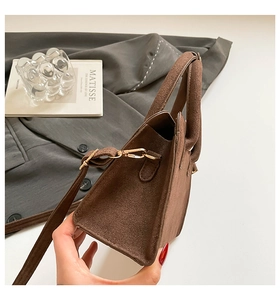 Detail of coffee brown matte suede Kelly bag featuring side structure and gold hardware