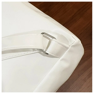 Macro detail of white leather backpack strap with reinforced stitching and silver ring