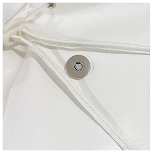 Detail of silver magnetic buckle and white leather drawstring on a minimalist backpack