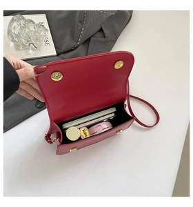 Internal capacity of the red leather handbag showing storage for smartphones and cosmetics