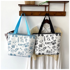 Detail of canvas tote bags with bear graffiti prints and woven straps in home setting