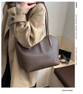 Detail of dark brown lychee grain leather tote bag with shoulder strap in a lifestyle setting