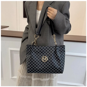 Detail of grey M-pattern monogram tote bag with gold logo and metal chain strap