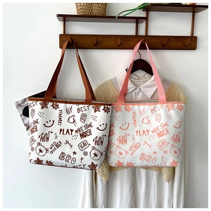 Detail view of canvas tote bags with graffiti bear prints and dual top handles on hooks