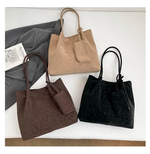 Flat lay of suede tote bags in khaki brown and black with matching coin purses