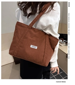 Brown corduroy tote bag showing fashion instinct label and large shoulder strap detail