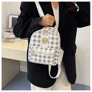 Détail du mini sac à dos blanc avec imprimé motif M et accents métalliques dorés