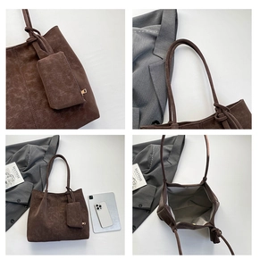 Detail view of large brown tote bag with inner lining, magnetic clasp, and small pouch