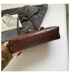 Détail du cabas en cuir marron foncé à motif crocodile et finitions en métal doré