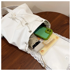 Top view of open white drawstring bucket bag showing spacious interior with daily essentials