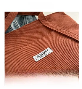 Detailed macro view of brick red corduroy fabric texture and fashion logo patch