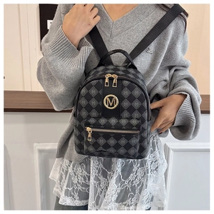 Détail d'un mini sac à dos gris avec matelassage à motif M et logo doré brillant