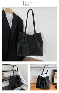 Detailed view of a black oversized vintage tote bag with matching small pendant pouch