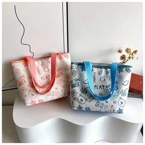 Close-up of graffiti print tote bags in pink and blue on white display stand