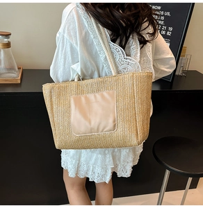 Detail of large straw tote bag with premium leather patch pocket and shoulder strap
