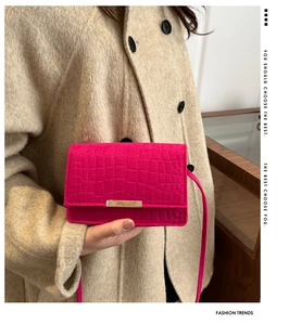 Close-up of fuchsia crocodile pattern mini flap bag with golden metal buckle clasp