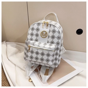 Vue détaillée du logo M doré et de l'imprimé monogramme sur le mini sac à dos blanc