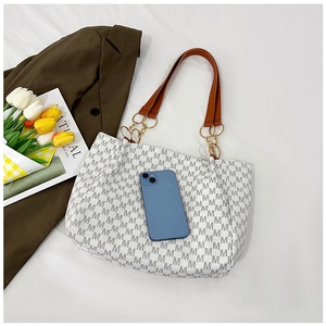 Macro view of M-pattern tote bag with a smartphone to show its large storage capacity