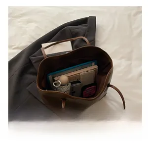 Detailed interior of a large brown tote bag showcasing spacious storage for tablet and umbrella