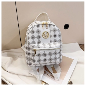 Détail du mini sac à dos beige avec motif à lettres M et logo en métal doré