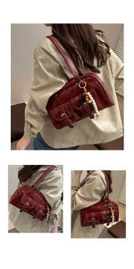 Dettaglio della borsa Boston vintage bordeaux con tasche a fibbia e ciondolo di perline