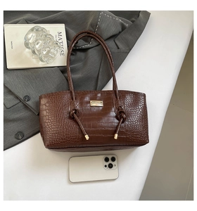 Détail du sac cabas marron café à motif crocodile avec plaque en métal doré