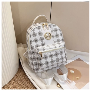 Détail du sac à dos blanc à motifs avec logo M en métal doré et finitions zippées