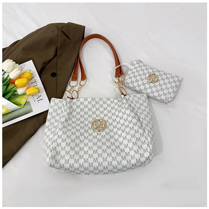 Detail of white tote bag with M-pattern print, brown leather strap and matching pouch
