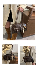 Dettaglio borsa bowling marrone lucida con tasche anteriori e ciondolo a perline