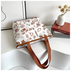 Macro shot of printed canvas tote bag with brown straps and cute bear graffiti patterns
