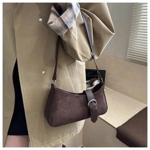 Close-up of dark brown suede crescent shoulder bag with vintage silver buckle detail