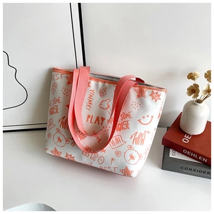 Close-up of white canvas tote with vibrant orange graffiti prints and sturdy handles