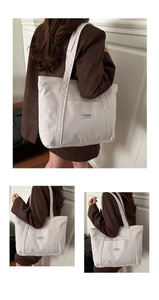 Detail of off-white corduroy tote bag featuring an outer pocket and a FASHION INSTINCT label