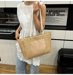 Close-up of woven tote bag with natural straw texture and thick white rope handles