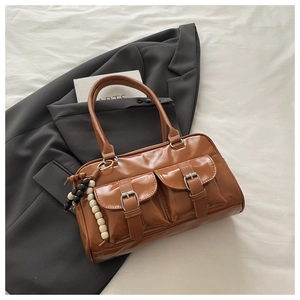 Detail view of brown glossy PU tote bag featuring dual front pockets and wood bead charm