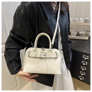 Detail view of white glossy handbag featuring metallic buckle and adjustable shoulder strap