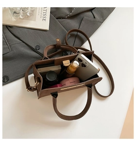 Macro shot of vintage brown matte tote bag showing spacious interior with personal items