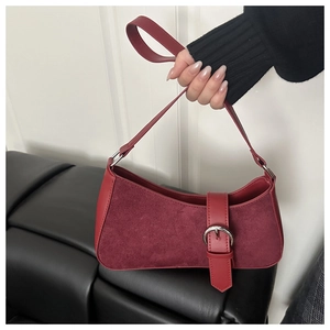 Détail du sac bandoulière croissant bordeaux avec textures daim et grande boucle argentée