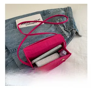 Capacity detail of a fuchsia croc-embossed mini bag showing space for phone and makeup
