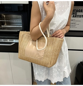 Detail of handwoven beige tote bag with leather patch and white rope handles