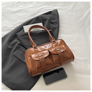 Detail of caramel faux leather bowling bag with front cargo pockets and silver buckles