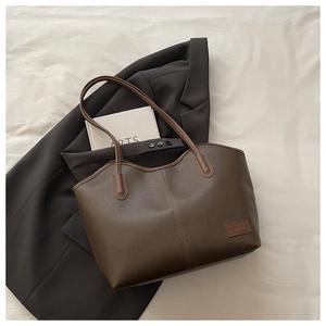 Detail of dark brown lychee leather tote bag with FASHION & BAGS branding
