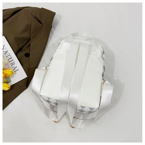 Détail d'un sac à dos blanc avec motif M, sangle nylon et boucles en métal doré