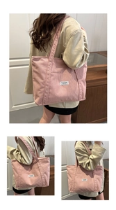 Detail of pink corduroy tote bag featuring a front pocket and white brand label detail