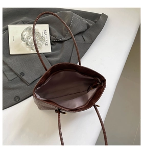 Détail d'un grand cabas marron à motif crocodile avec fermeture éclair et doublure