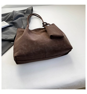Detail view of deep brown vintage tote bag with matching coin purse and suede texture