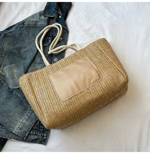Detail of woven straw tote bag with rope handles and Fashion Bags text on a casual patch